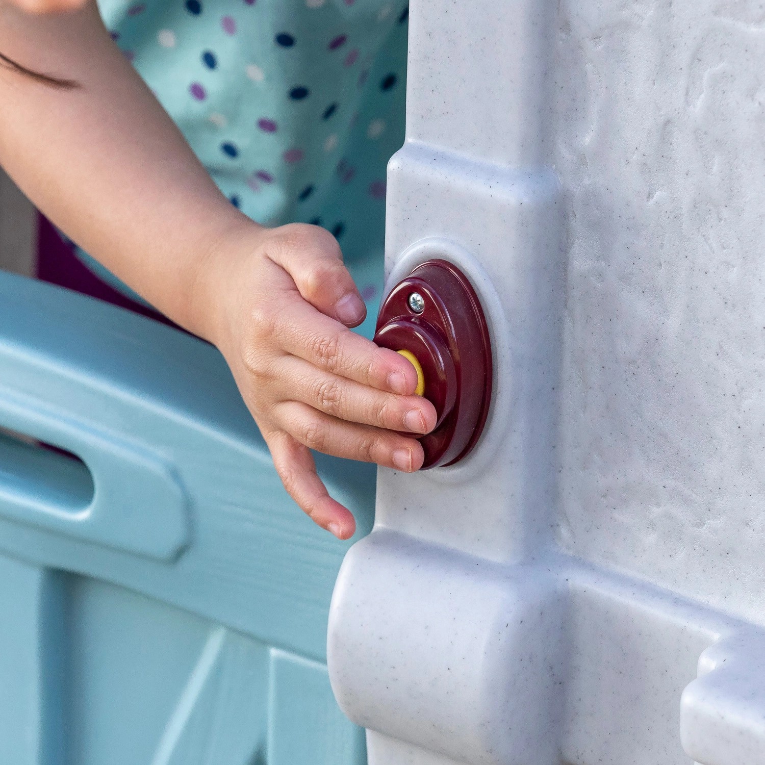 Kind drückt Klingel am Step2 Spielhaus Adventures. Zweistöckiges Spielhaus mit Rutsche.