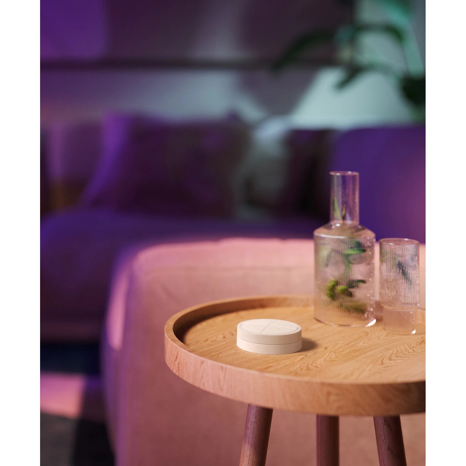 Philips Hue Tap Dial Schalter in Weiß auf Holztisch, smarte Lichtsteuerung.