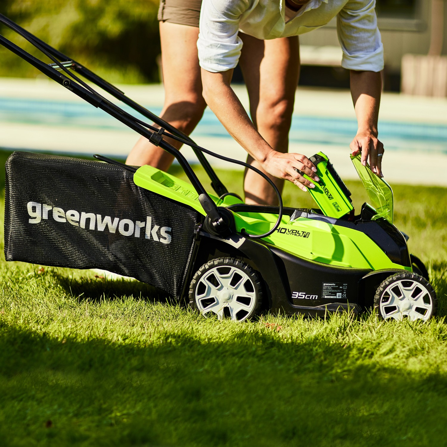 Greenworks Akku-Rasenmäher G40LM35K2 Set mit eingesetztem Akku auf Rasen.