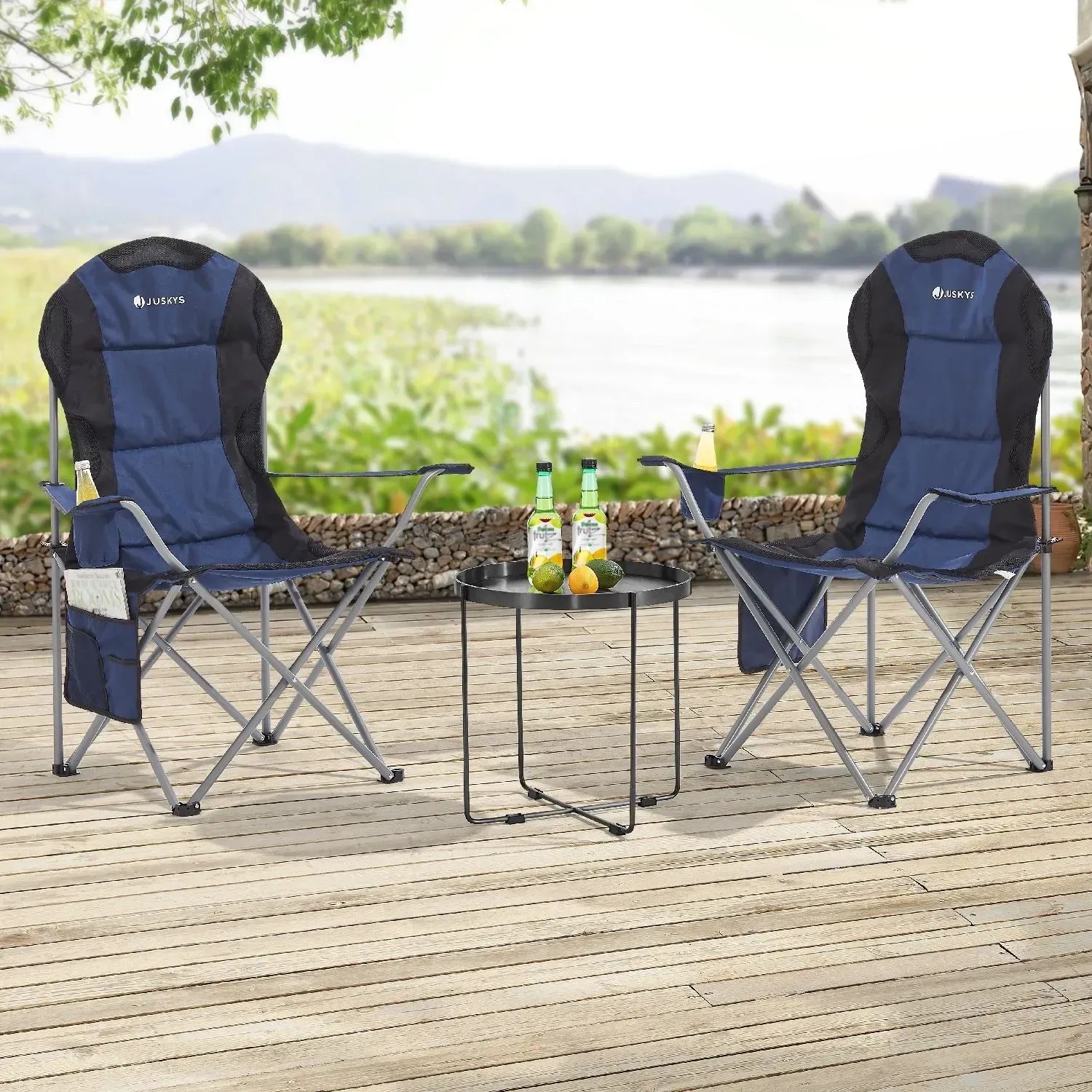 Zwei dunkelblaue Juskys Campingstühle Lido mit Getränkehalter und Tisch auf einer Terrasse.