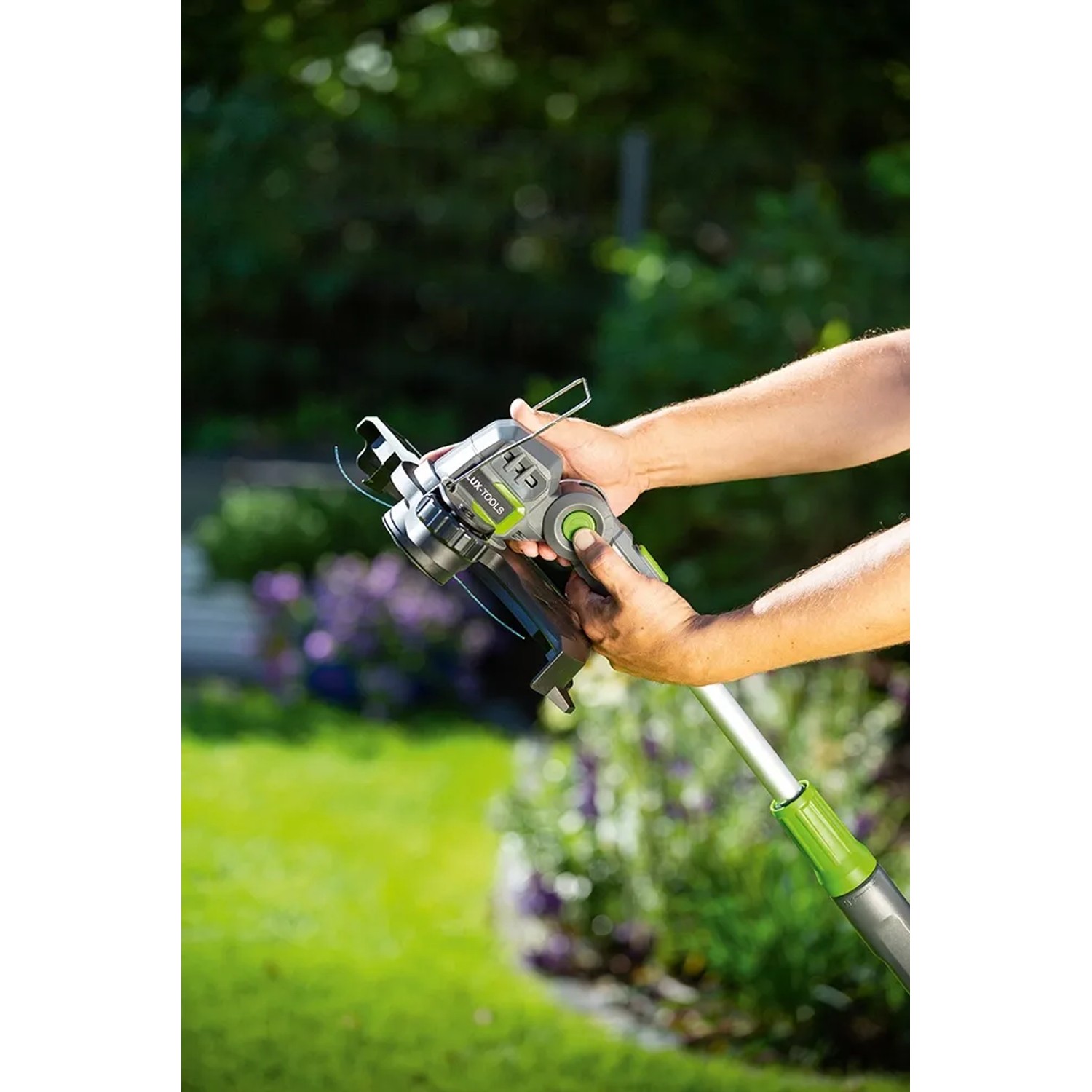 LUX Akku-Rasentrimmer A-RT-20/25 in Aktion, kabelloser Trimmer mit Teleskopstiel und Pflanzenschutzbügel.