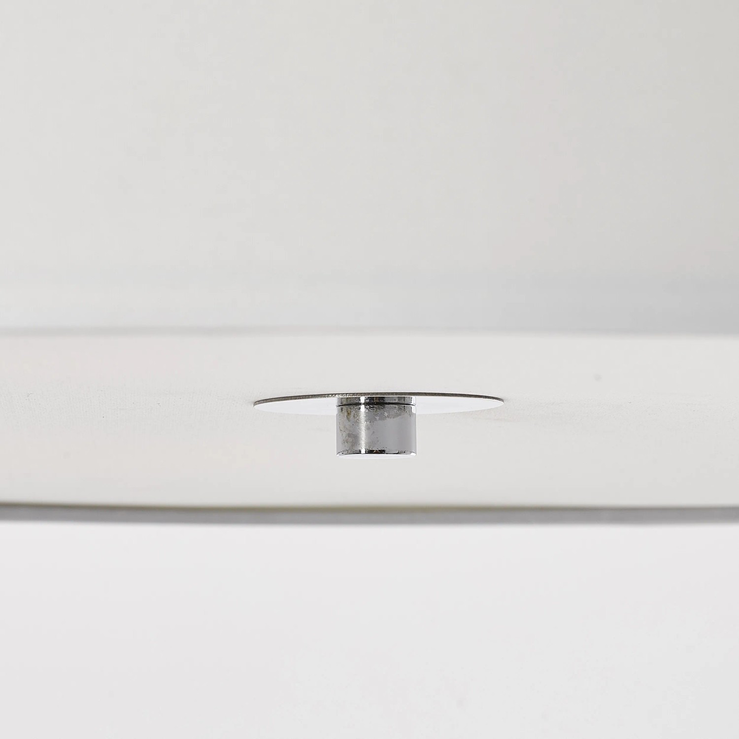 Detailaufnahme der weißen Brilliant Deckenleuchte Andria mit Chrom-Elementen.