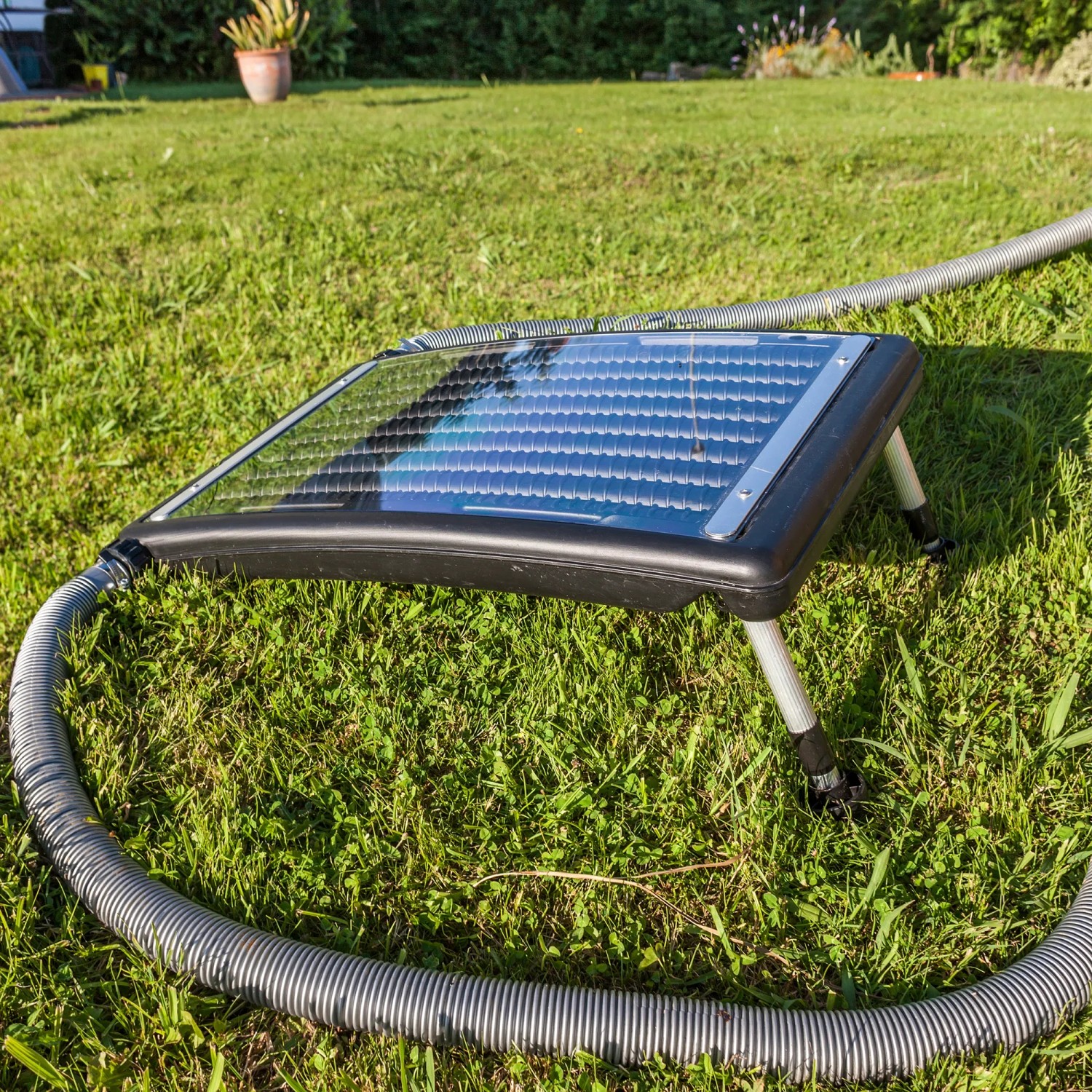 Gre Solarwärmepaneel zur Poolheizung, schwarzer Rahmen, auf Rasen mit Schlauch.