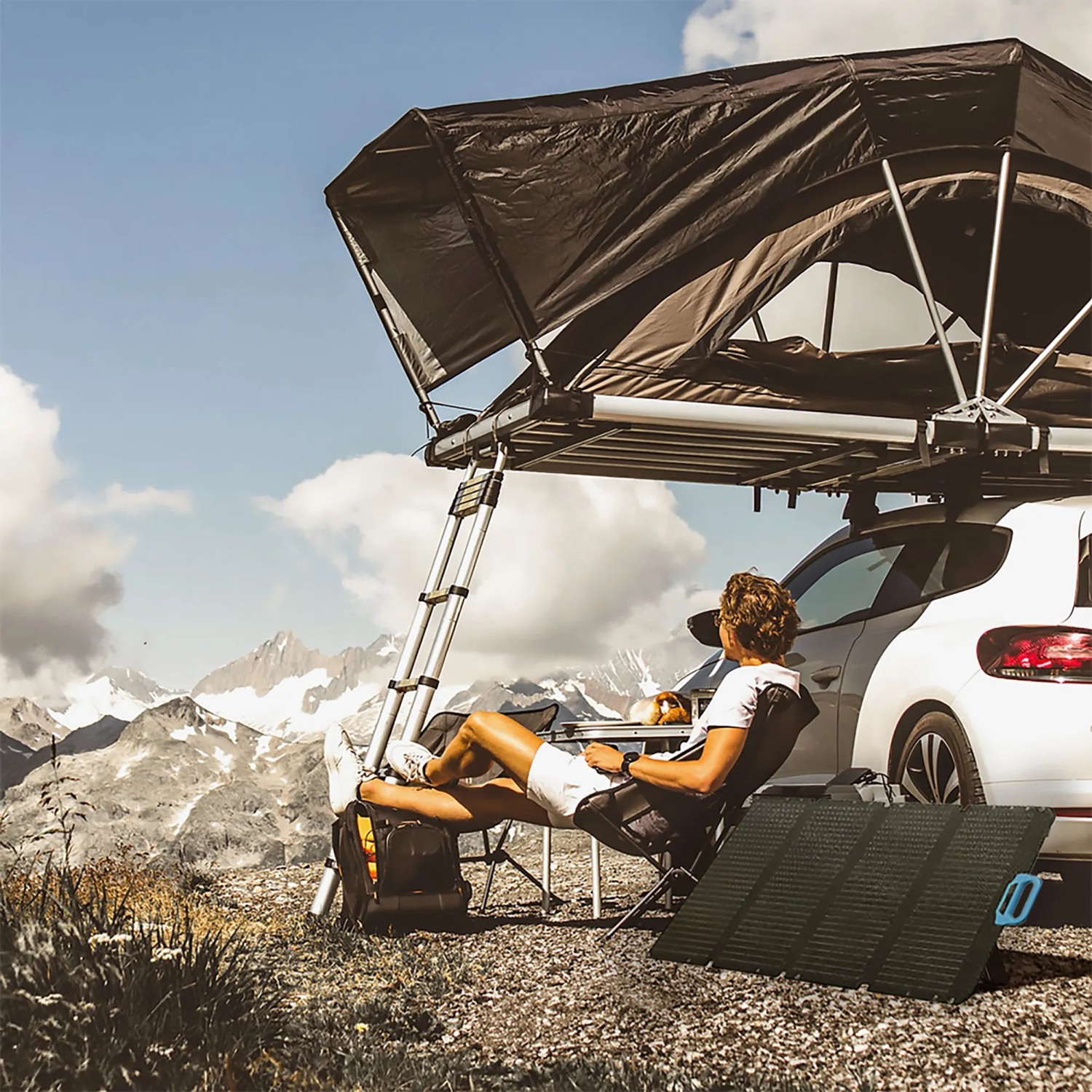 Faltbares 100W Solarpanel im Einsatz beim Camping mit Dachzelt auf einem Auto.