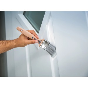 Lackierarbeiten mit LUX Flachpinsel 60mm: Hand führt Pinsel auf weißer Oberfläche.