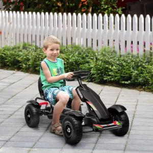 Kind fährt schwarzes HOMCOM GoKart Tretfahrzeug mit Gummireifen und verstellbarem Sitz auf gepflastertem Weg.