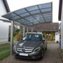 Ximax Carport Portoforte-80 im Edelstahl-Look mit Auto. Moderner Metallcarport mit gebogenem Dach.