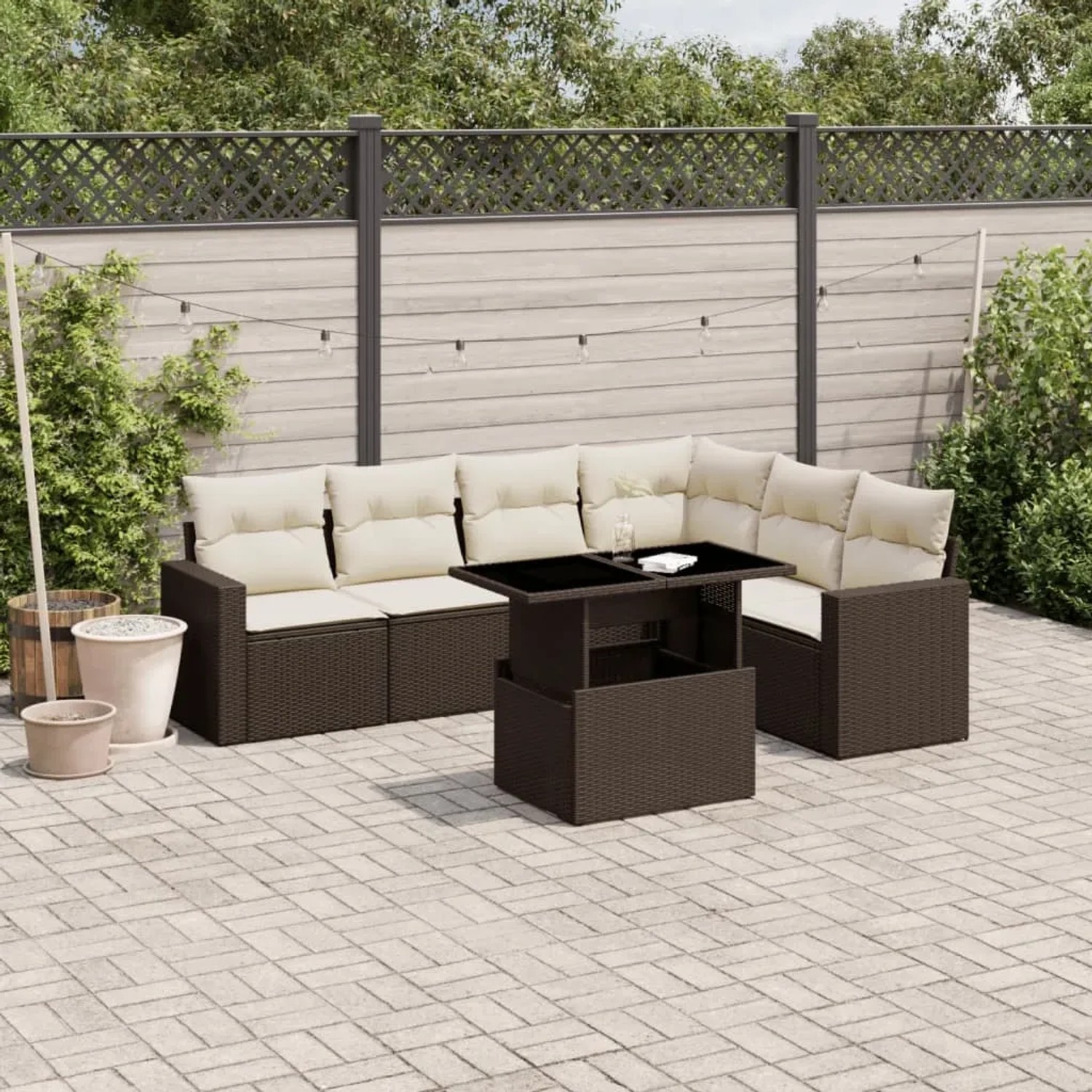 Braune 7-tlg. vidaXL Garten-Sofagarnitur aus Poly Rattan mit cremefarbenen Kissen und Tisch mit Glasplatte.