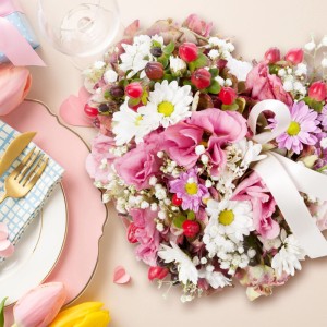 Herzförmiges Blumenarrangement mit rosa und weißen Blumen, Beeren und Schleife, als kreative Steckschaum Deko.