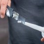 Hand schneidet weiße wolfcraft Kartuschenspitze mit Messer. Vorbereitung für Dicht- und Klebestoffe, Maurer- & Verlegewerkzeuge.