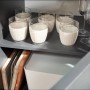 Innenansicht Küchenzeile Oliver Grau Matt: Gläser, Backbleche und Behälter im Schrank.