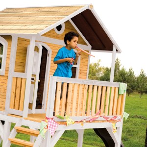 Axi Spielhaus Sophie mit Rutsche: Holzhaus in Braun/Weiß mit Kind auf Veranda.