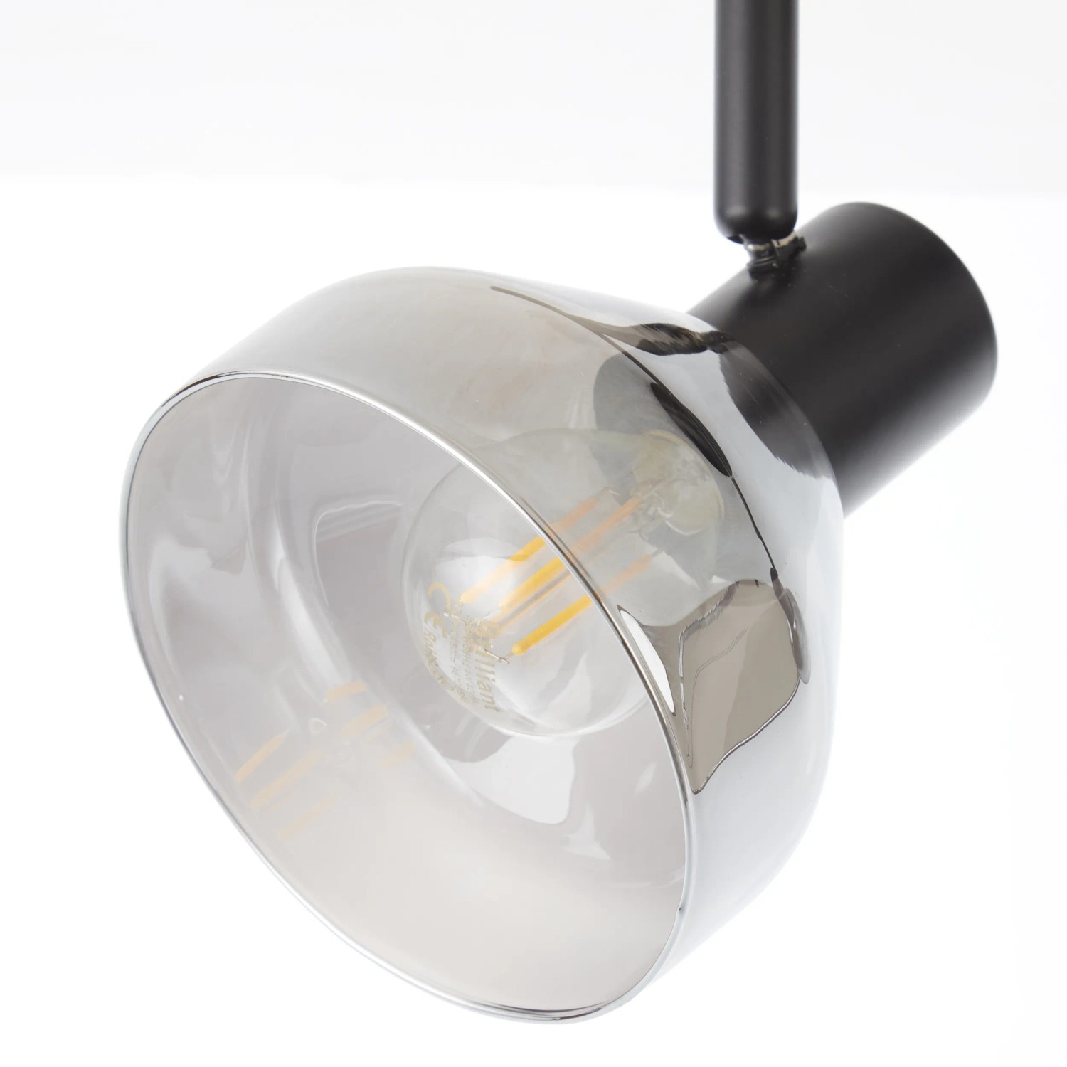 Detailaufnahme: 4-flammiges Spotrohr Reflekt in Schwarz matt mit Rauchglas-Schirmen.
