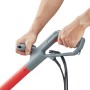 Detailaufnahme: Hände bedienen den Griff des CMI Elektro-Rasentrimmers. Elektro-Trimmer mit rotem Schaft.