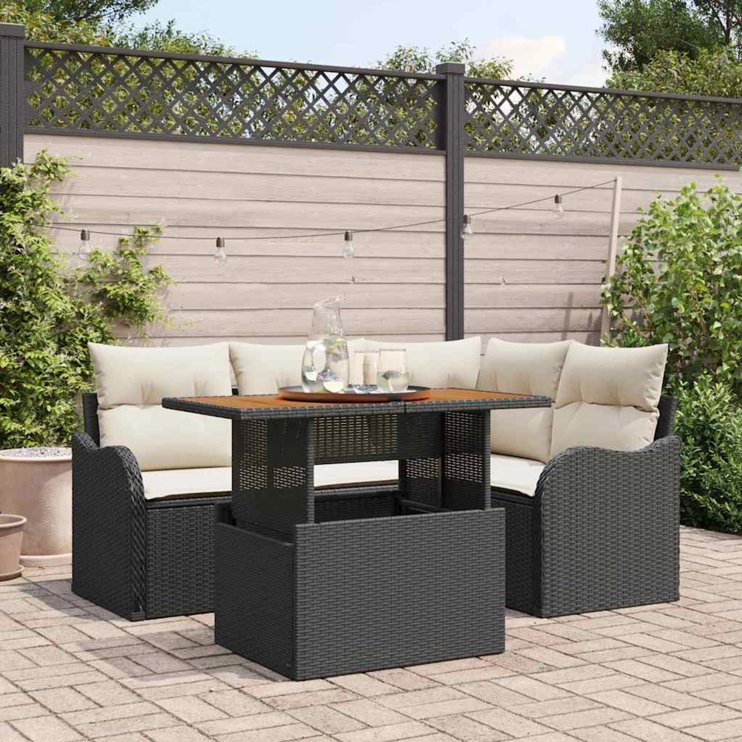 Schwarzes 5-teiliges Gartenmöbel Set aus Poly Rattan mit Tisch und Kissen.
