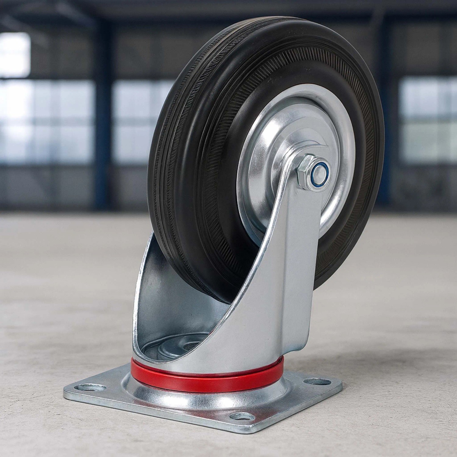Robuste Lenkrolle mit schwarzem Vollgummirad, 125mm, silberner Metallfelge und rotem Drehring für 100kg Last.