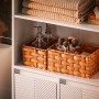 Detailaufnahme: Weißer SoBuy Hochschrank mit Badutensilien und geflochtenen Körben.