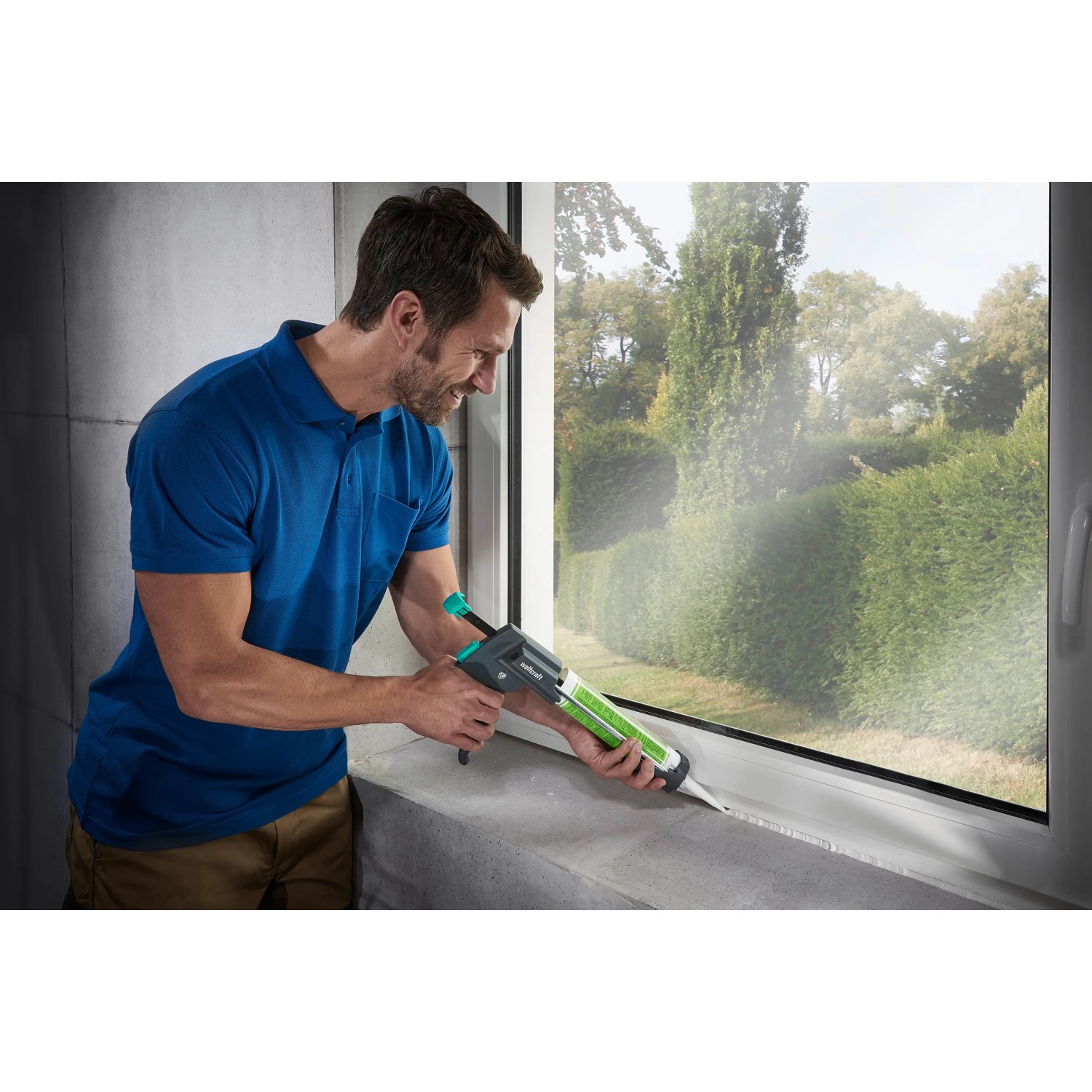 Mann benutzt wolfcraft Kartuschenpresse MG 600 Pro zum Abdichten eines Fensters.
