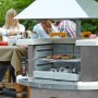 Buschbeck Grillkamin Zürich Anthrazit-Weiß mit Edelstahlhaube beim Grillen im Garten.
