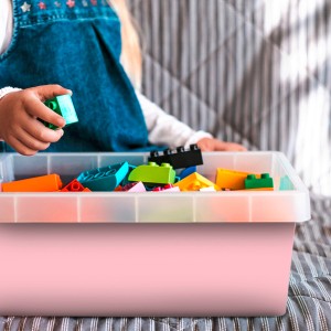 Klebefolie Puderrosa (45x200cm) in Anwendung mit Spielzeugsteinen in rosa Box.