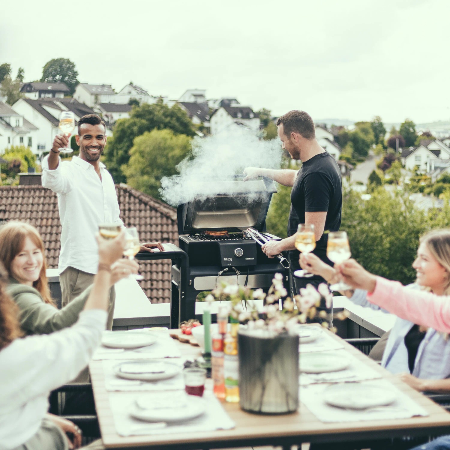 Gruppe feiert mit dem Severin Standgrill PG 8139 Sevo Smart Control GTS auf der Dachterrasse.