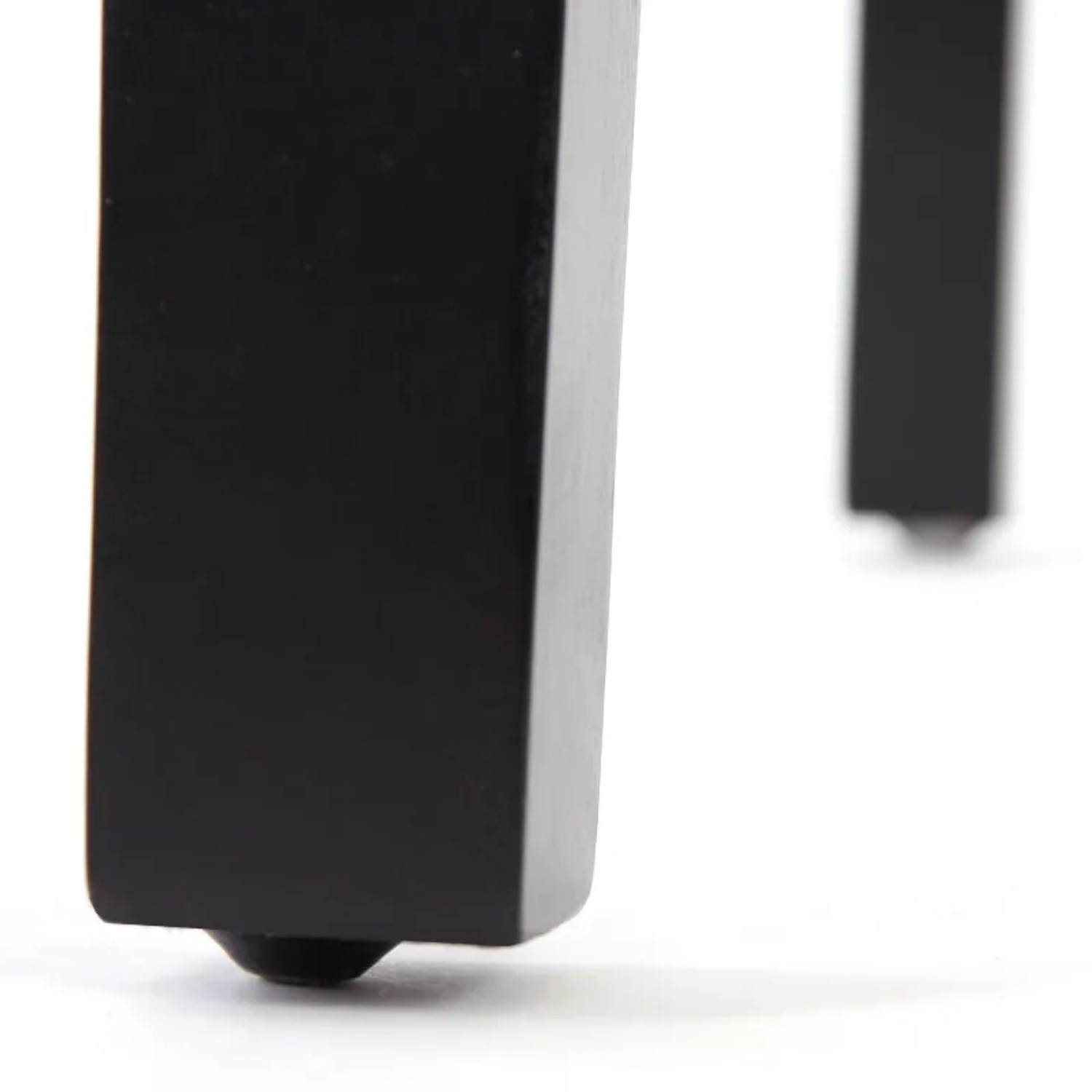 Detailaufnahme: Dunkle Holzbeine des weißen MCW Esszimmerstuhls Littau mit Lederbezug.