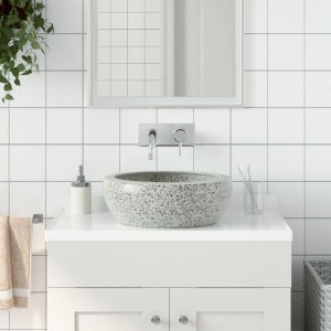 Graues, rundes Keramik Aufsatzwaschbecken mit gesprenkeltem Muster auf Waschtischplatte im modernen Bad.