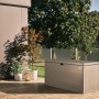 Quarzgraue Biohort StyleBox 140 Universalbox auf Holzterrasse. Regenwasserdichte Gartenbox mit glatter Oberfläche.