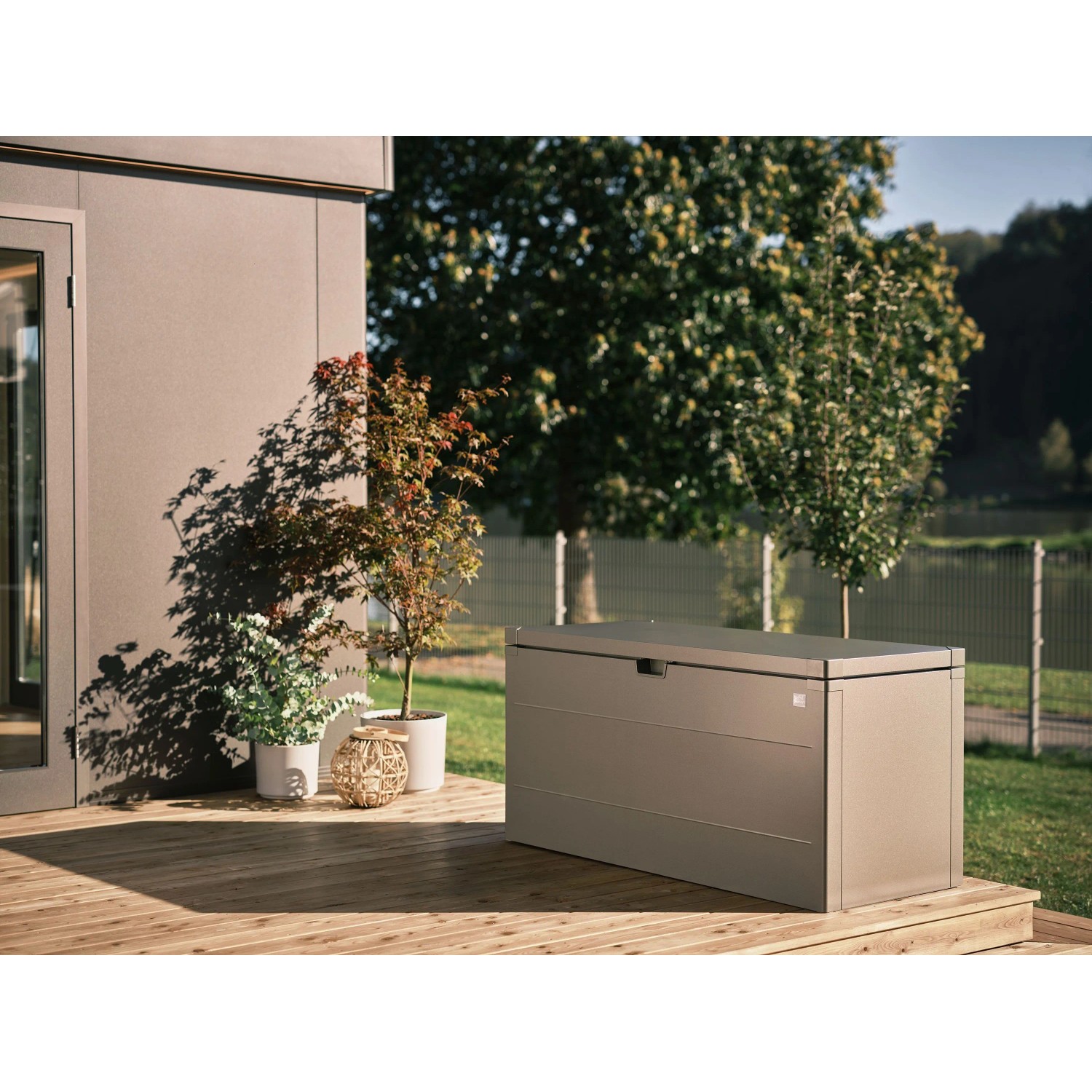 Quarzgraue Biohort StyleBox 140 Universalbox auf Holzterrasse. Regenwasserdichte Gartenbox mit glatter Oberfläche.