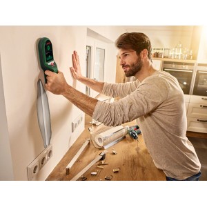 Mann nutzt Bosch UniversalDetect Ortungsgerät an Wand, um Leitungen zu finden.