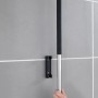 Wenko Edelstahl Boden- und Fensterwischer Rosole mit Wandhalterung an grauer Wand.