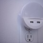 Osram LED-Nachtlicht Lunetta USB, ein weißes, rundes Nachtlicht mit USB-Anschlüssen in einer Steckdose.