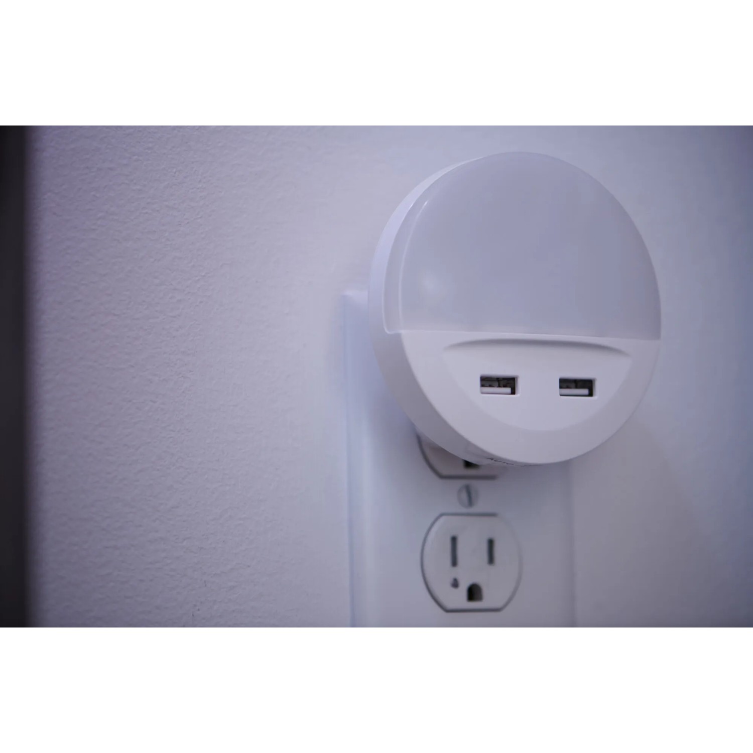 Osram LED-Nachtlicht Lunetta USB, ein weißes, rundes Nachtlicht mit USB-Anschlüssen in einer Steckdose.