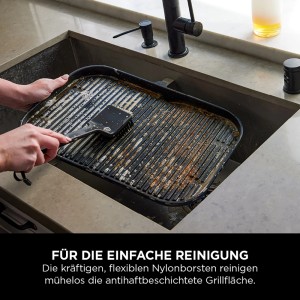 Ninja Grillreinigungsbürste Woodfire in Aktion: Grillrost wird in Spüle gereinigt.