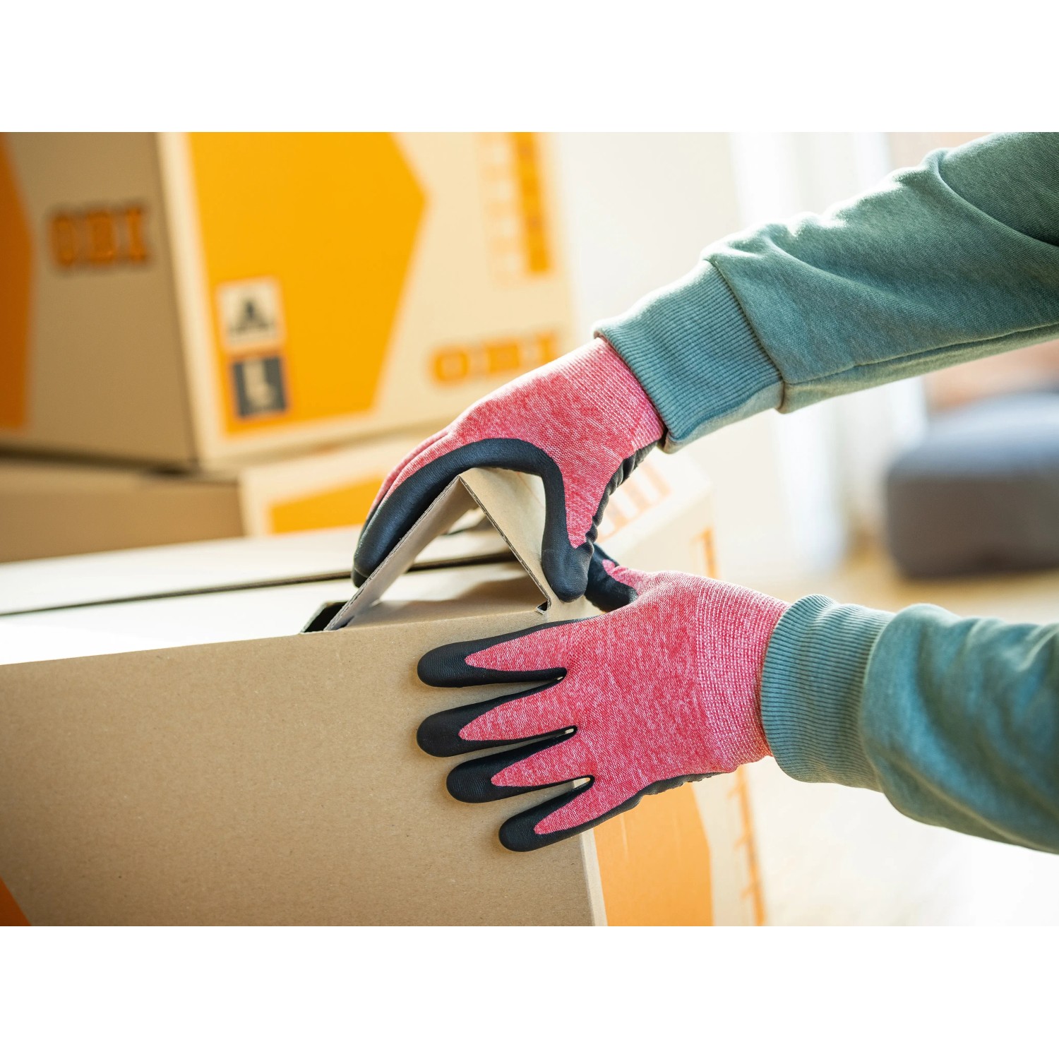 Hände mit LUX Allroundhandschuhen (Gr. 8) beim Tragen eines Kartons. Arbeitshandschuhe für Damen.