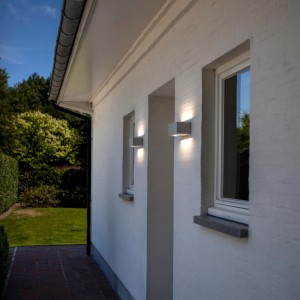 Zwei weiße LUTEC LED-Außenwandleuchten Gemini an einer Hauswand.