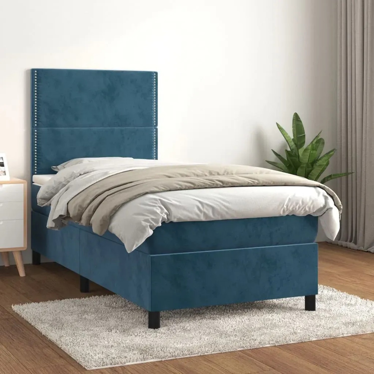 Dunkelblaues Boxspringbett (100x200 cm) mit Samtbezug, Matratze und Kopfteil im Schlafzimmer.