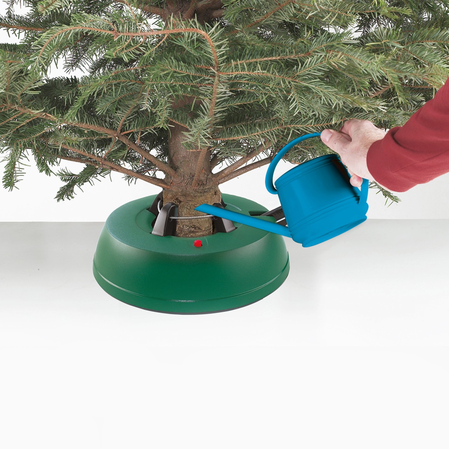 Grüner OBI Basic Christbaumständer mit Baum und Gießkanne beim Bewässern.