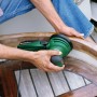 Grüner Bosch Exzenterschleifer PEX 220 A schleift Holz. Leistungsstarke Schleifmaschine für feine Oberflächen.