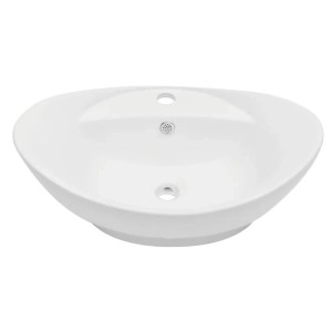 Ovales, weißes Keramik Waschbecken als Teil eines Badmöbel-Sets.