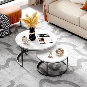 Zwei runde, stapelbare Beistelltische mit weißer Marmorplatte und schwarzem Metallrahmen im modernen Wohnzimmer.