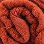 Gerollte, terracottafarbene Babydecke aus Mikrofaser (70x100 cm).