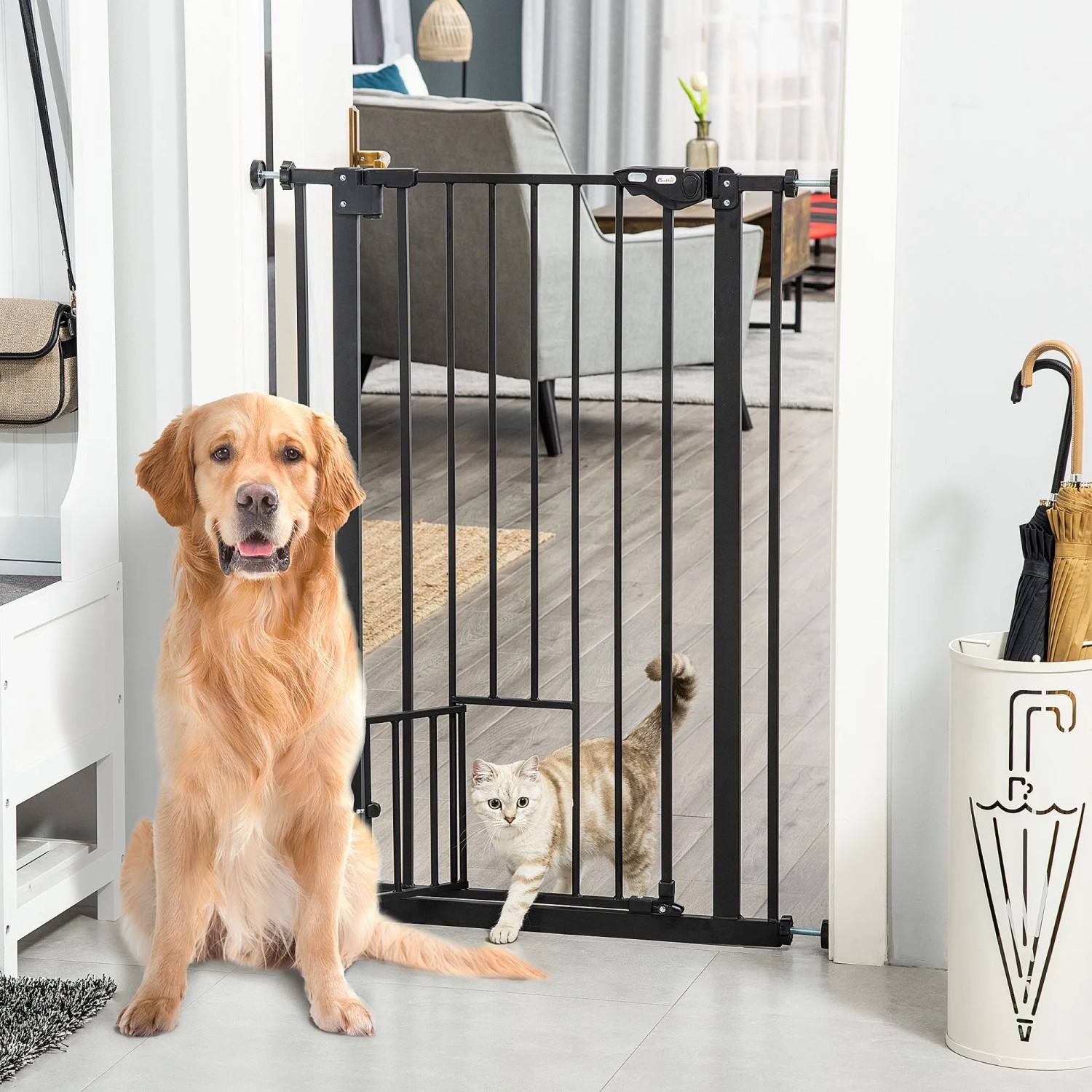 PawHut Türschutzgitter mit Katzenklappe, schwarzes Metall. Hund sitzt, Katze geht durch das Gitter.