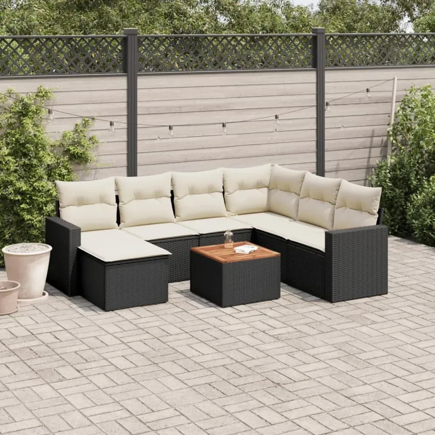 Schwarze 8-tlg. Garten-Sofagarnitur aus Rattan mit cremefarbenen Kissen und Tisch.