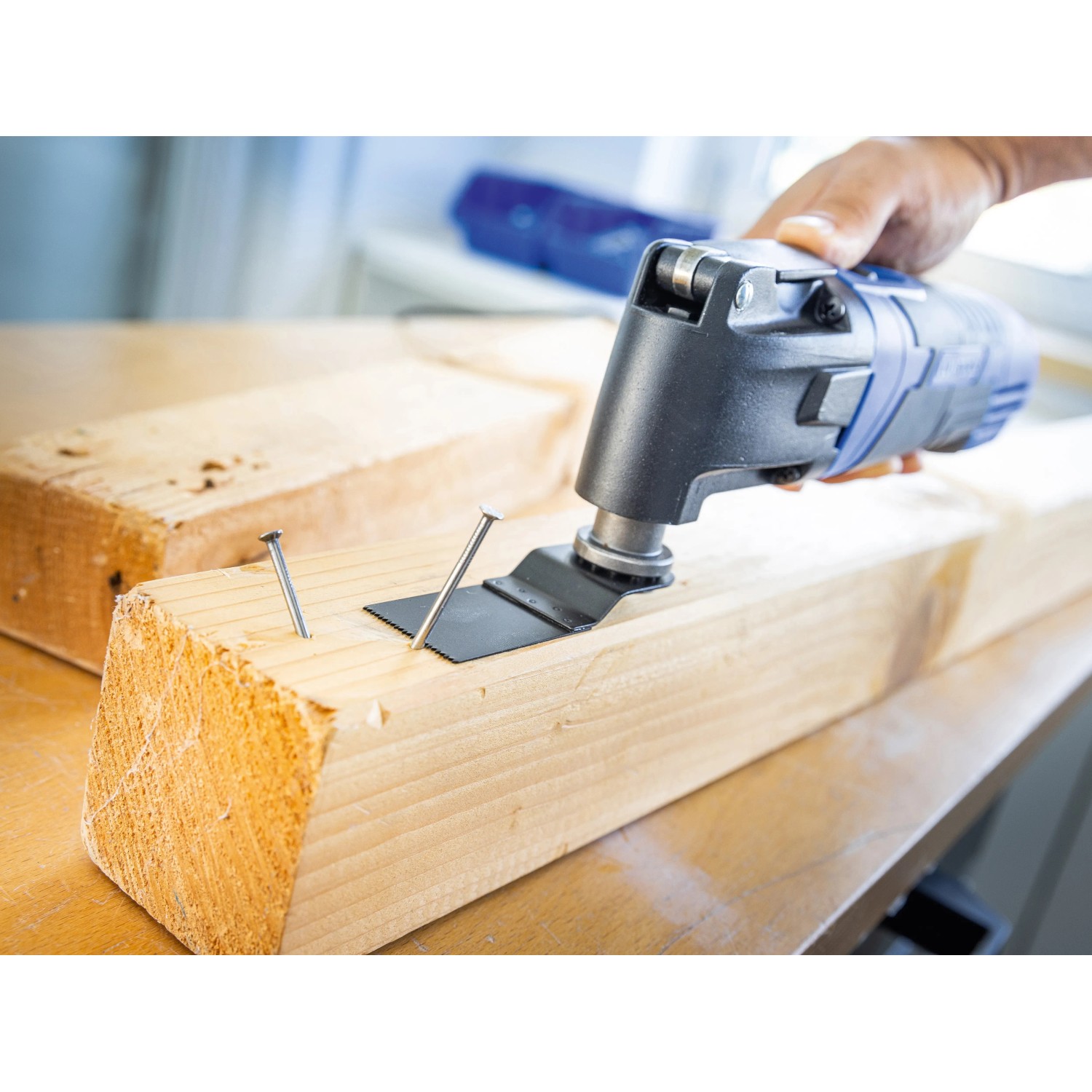 LUX Multitool E-MFW-23 in Aktion: Multifunktionswerkzeug sägt Nagel in Holz. Vielseitiges Elektrowerkzeug.