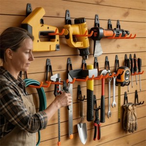 Frau organisiert Werkzeuge mit Relaxdays Wandhaken Set Schwarz/Orange aus Edelstahl/PVC. 12-teiliges Ordnungssystem.