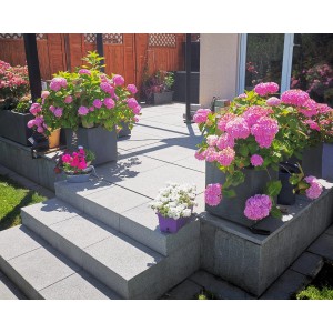 Ondis24 Pflanzkübel Vulkan 50 in Pierre Grau mit üppigen rosa Hortensien auf einer Terrasse.