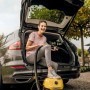 Frau nutzt Kärcher Nass-/Trockensauger WD 3 V-17/4/20 im Kofferraum eines Autos.