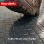 Dunkelgrauer PVC-Bodenbelag mit Quadratmuster und Schuh für Rutschfestigkeit.
