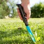 Gardena Unkrautstecher im Einsatz: Hand entfernt Unkraut aus dem Rasen mit dem Unkrautentferner.